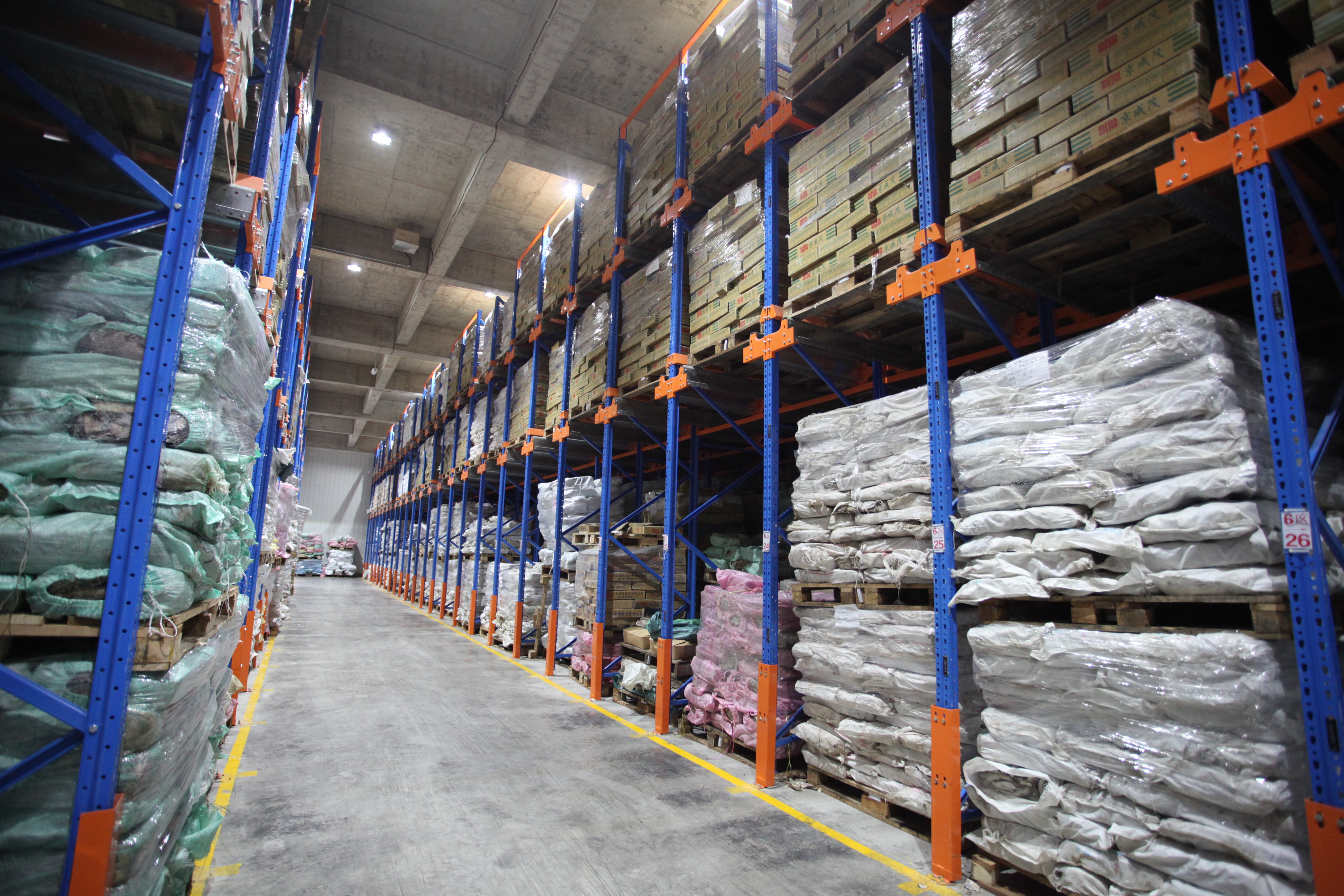 Pallet rack interior at the Baixian Strait Logistics Center — high-bay shelving with palletised inventory under intelligent shelf-position management.
